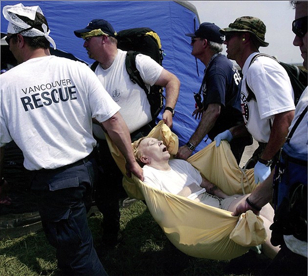 Chalmette, LA -- Fire and rescue team members from Vancouver, Canada, carried an elderly woman to a medical tent after she was evacuated. Surrounded by several family members, the woman died moments later. 