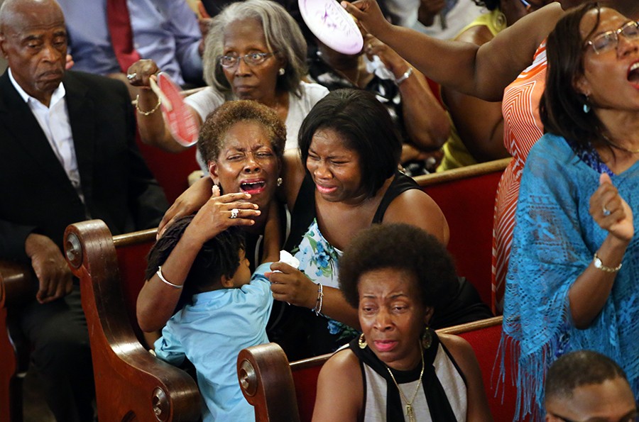 Grieving mourners fill the pews as Emanuel AME Church re-opens its doors for Sunday services four days after nine parishioners were slain by a white supremacist during a Bible study. The shooting occurred in the basement of the church, directly below the sanctuary where mourners are gathered for the Sunday service. (Paul Zoeller, The Post and Courier - July 21, 2015).