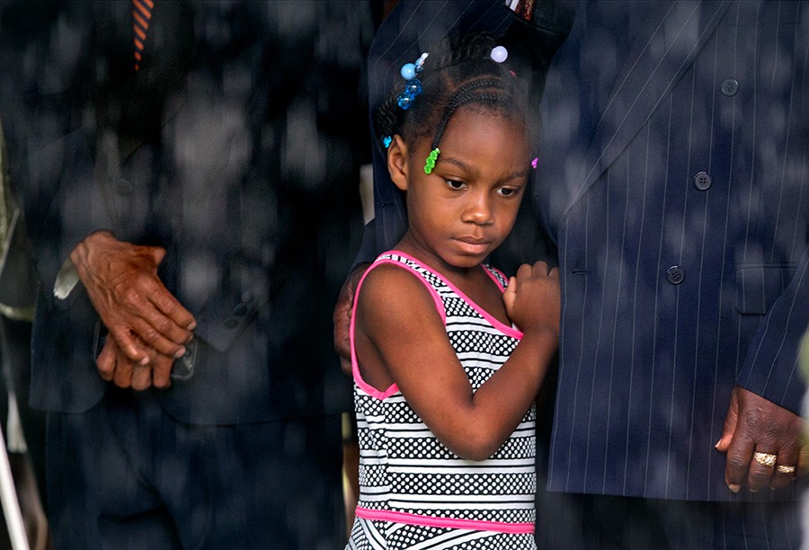 Samariah Johnson, 6, watches from under a tent as rain falls during funeral services for Cynthia Hurd, librarian and community leader at the Emanuel AME Church graveyard. Hurd was among nine killed in a mass shooting at the church. (Paul Zoeller, The Post and Courier - June 27, 2015)
