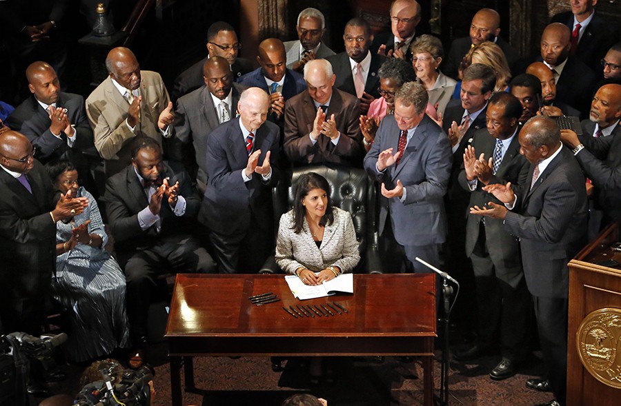Cheering and applause fill the rotunda as South Carolina Gov. Nikki Haley, surrounded by former South Carolina governors and state lawmakers, signs a bill into law removing the Confederate battle flag at the Statehouse in Columbia. (Paul Zoeller, The Post and Courier - Thursday, July 9, 2015).