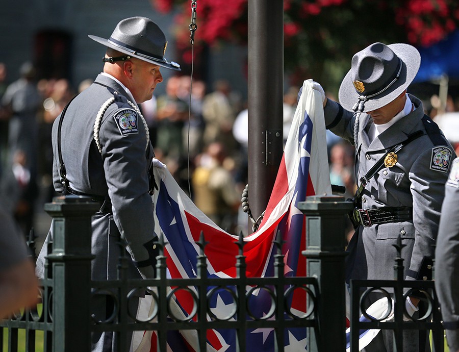 An honor guard from the South Carolina Highway Patrol removes the Confederate battle flag from the Statehouse grounds in Columbia, S.C. (Grace Beahm, The Post and Courier - July 10, 2015).