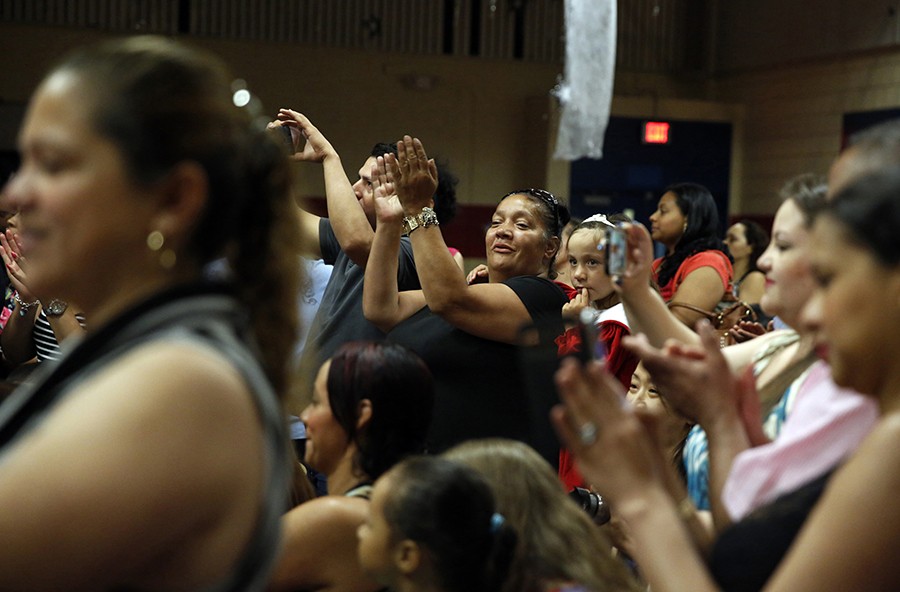 Surrounded by other proud parents Raquel claps and cheers during Mimi's kindergarten graduation ceremony. It had been a dark spring, but after completing a three-week outpatient addiction program, Raquel was feeling hopeful (Jessica Rinaldi, The Boston Globe).