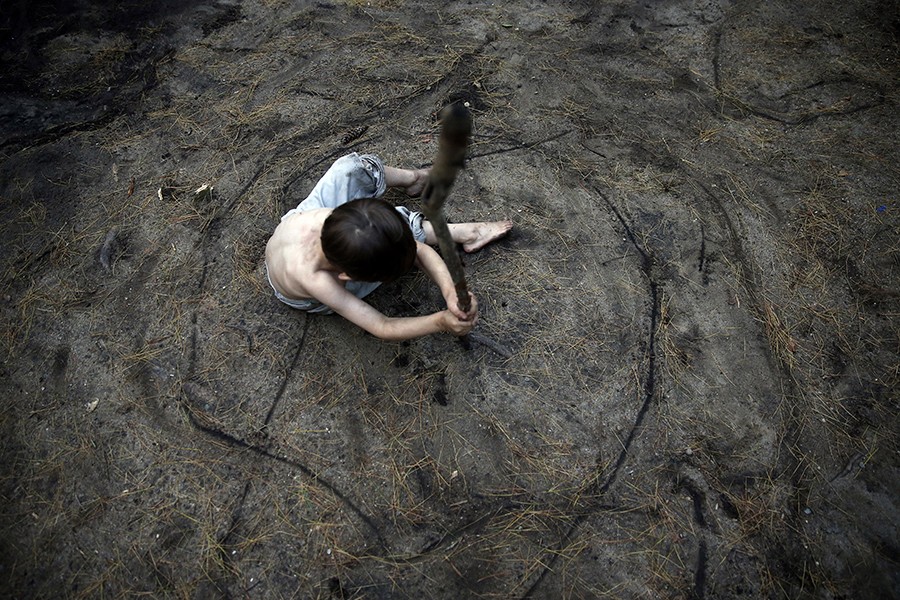 Having moved into their fourth campground of the summer, Gallagher sits in the center of a circle that his brother, Strider, has etched around him in the dirt. According to the state, living in a campground means they no longer have a house payment, because of this, their food stamps have been cut by a hundred dollars (Jessica Rinaldi, The Boston Globe).