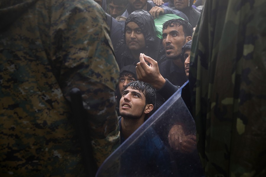 Migrants and refugees beg Macedonian policemen to allow passage to cross the border from Greece into Macedonia during a rainstorm, near the Greek village of Idomeni (Yannis Behrakis, Thomson Reuters - September 10, 2015).