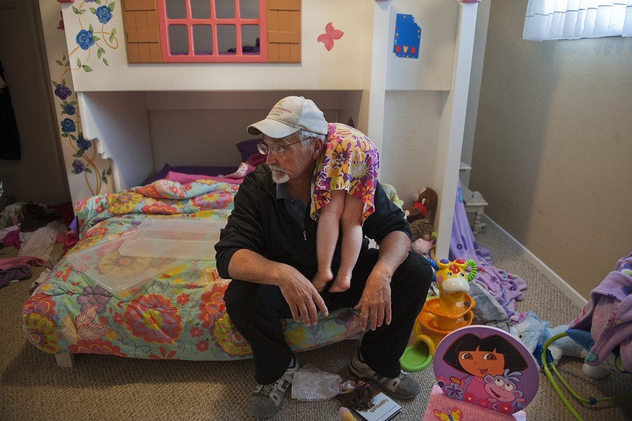 Ariel, 3, hangs over her grandfather Don Hatfield's shoulder after balancing and dancing on his knee and following him throughout the house. (April 6, 2012)