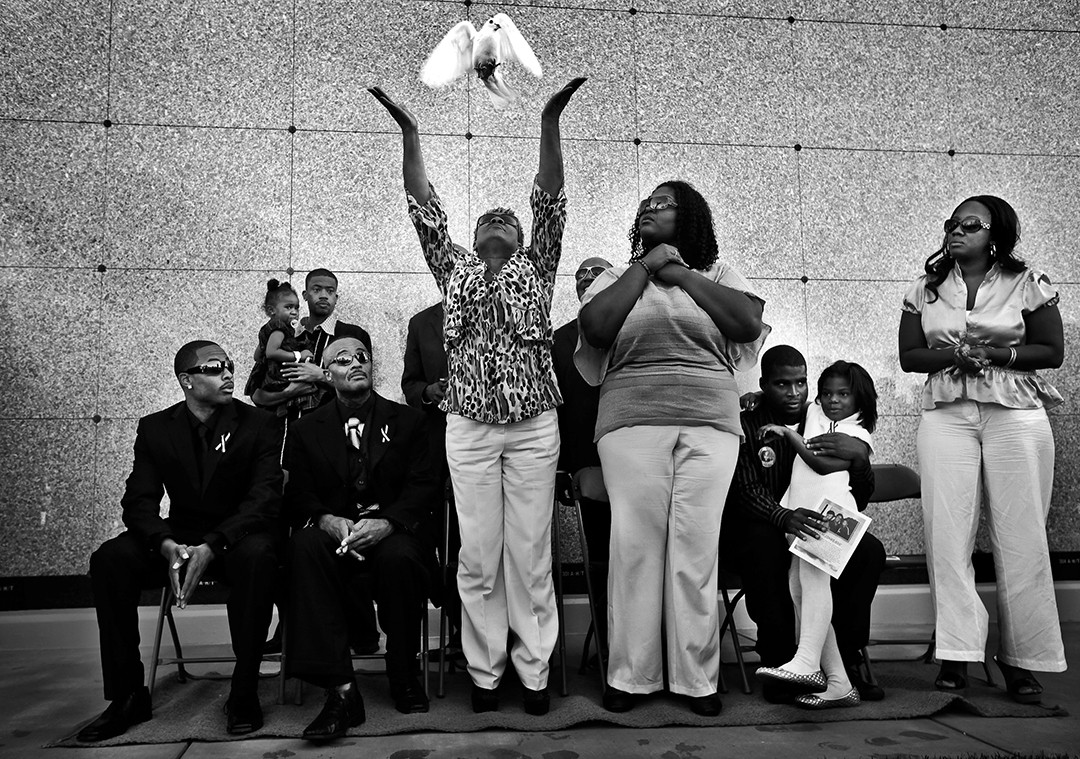 A dove is released at the recent memorial service for 5-year-old Aaron Jerel Shannon Jr., who died after he was shot in the head by a stray bullet on Halloween. Shannon had been modeling his new Spider-Man costume in the backyard of his South Los Angeles home. Aaron's father and grandfather, his primary caretakers, are seated at left. Nearly 400 people gathered at the City of Refuge Church in Gardena to say goodbye to the boy (Barbara Davidson, Los Angeles Times- December 29, 2010)