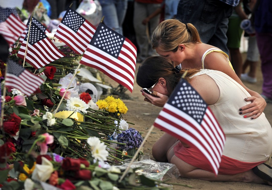 Amanda Medek, the sister of victim Micayla Medek, 23, is overcome with grief as she sits in front of a cross that was made for her sister. (Helen H. Richardson - July 22, 2012)