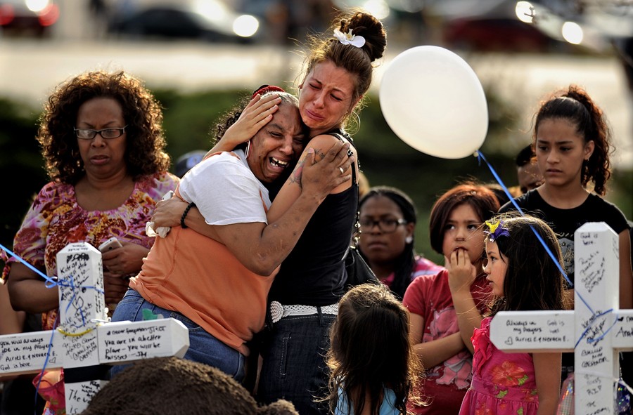 People comfort each other at the memorial for shooting victims at the corner of E. Centerpoint Dr. and S. Sable Blvd. in Aurora, CO. Sunday, July 22, 2012. (Hyoung Chang - July 23, 2012)