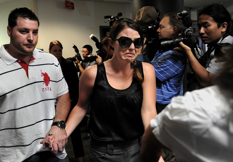 Amanda Medek cries as she is led through a gauntlet of photographers on her way to the courtroom to witness a hearing for James Holmes, the man accused of killing 12 people, including Medek's sister, Micayla, and injuring 58 others. (Joe Amon - July 23, 2012)