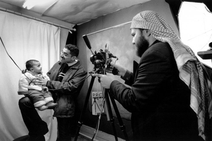 In Amman, Jordan, Hadia took her family to a portrait studio to get their passport photos. Ali the baby boy whom Raheem and Saleh would soon meet, was bounced on an assistant's knee in order to keep him awake for the picture.