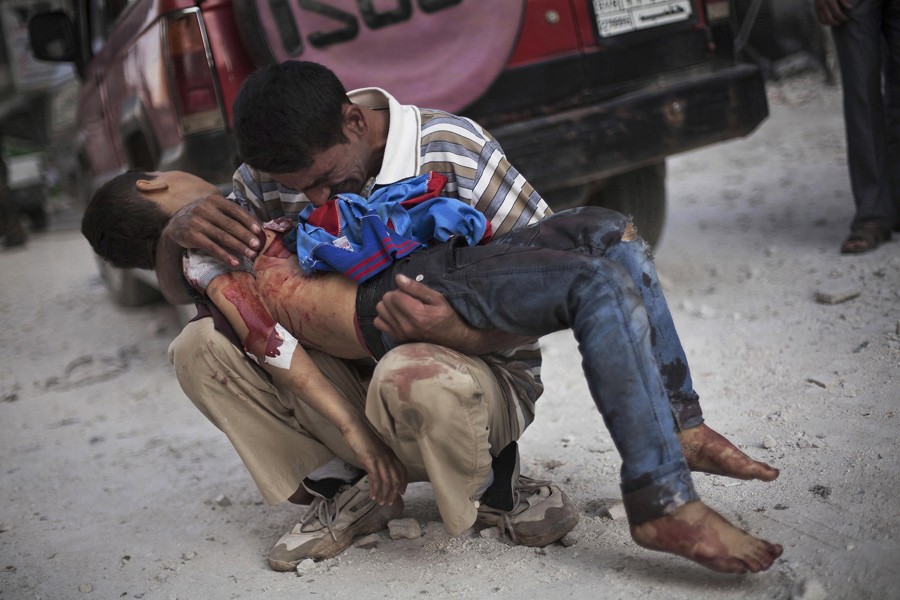 A Syrian man cries while holding the body of his son near Dar El Shifa hospital in Aleppo, Syria, Oct. 3, 2012. The boy was killed by the Syrian army. (Manu Brabo, Associated Press - October 3, 2012)