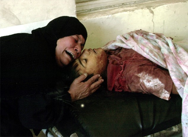 Baghdad - The mother of Samah Hussein grieves over the body at a Baghdad morgue. The boy was among 12 people reportedly killed by a suicide car bombing outside the U.S. military's Camp Cuervo. 