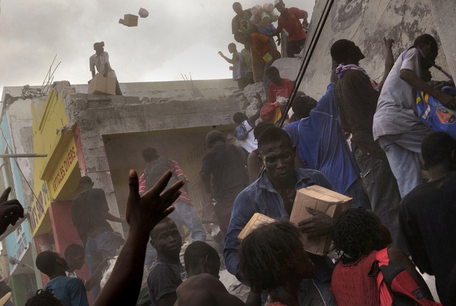 'Need' After going days without food or water, survivors take goods from a store on the main commerce street in Port-au-Prince as dust fills the air. Police assigned to control the crowd would return to scavenge for the same goods. Although a few trucks could be spotted in the capital delivering water, residents said they were becoming increasingly hungry. Many of those in need of food and medicine were children. (Nikki Kahn, The Washington Post - January 17, 2010)