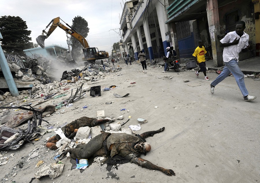 'Death' The smell of death and ash permeates the air as decomposing bodies are pulled from the rubble. For days after the quake, it was mainly the people of Port-au-Prince, working with bare hands and simple tools, who pulled at slabs of concrete and blocks of debris to get at those still trapped. Some were eventually able to get heavy machinery to tear down destroyed buildings, finding many victims who had been trapped when concrete floors collapsed. (Carol Guzy, The Washington Post - January 26, 2010)